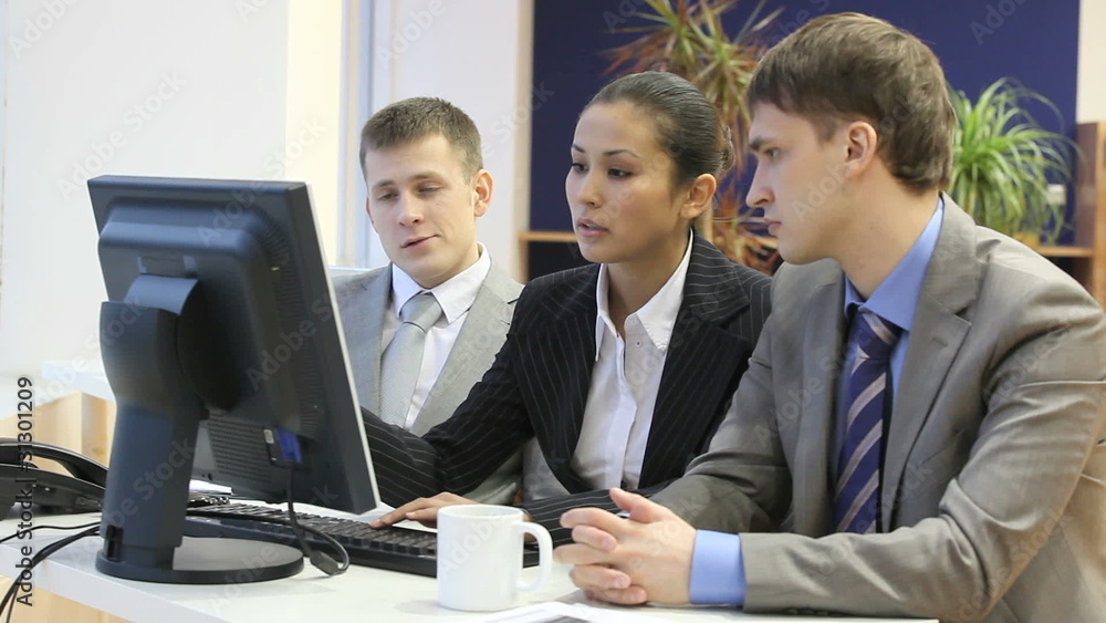Businesspeople doing computer work and discussing Businesspeople doing computer work and discussing