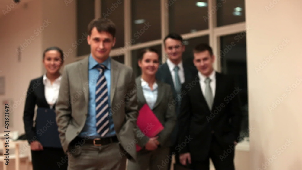 Business team behind their leader looking at camera