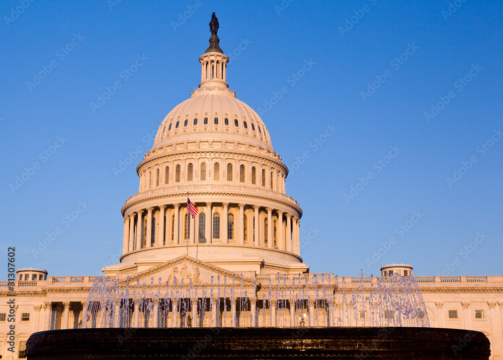 Obraz premium Rising sun illuminates the front of the Capitol building in DC