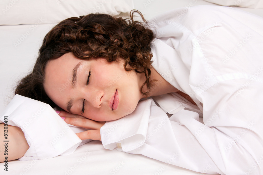 Beautiful young woman sleeps on the white bed Beautiful young woman sleeps on the white bed