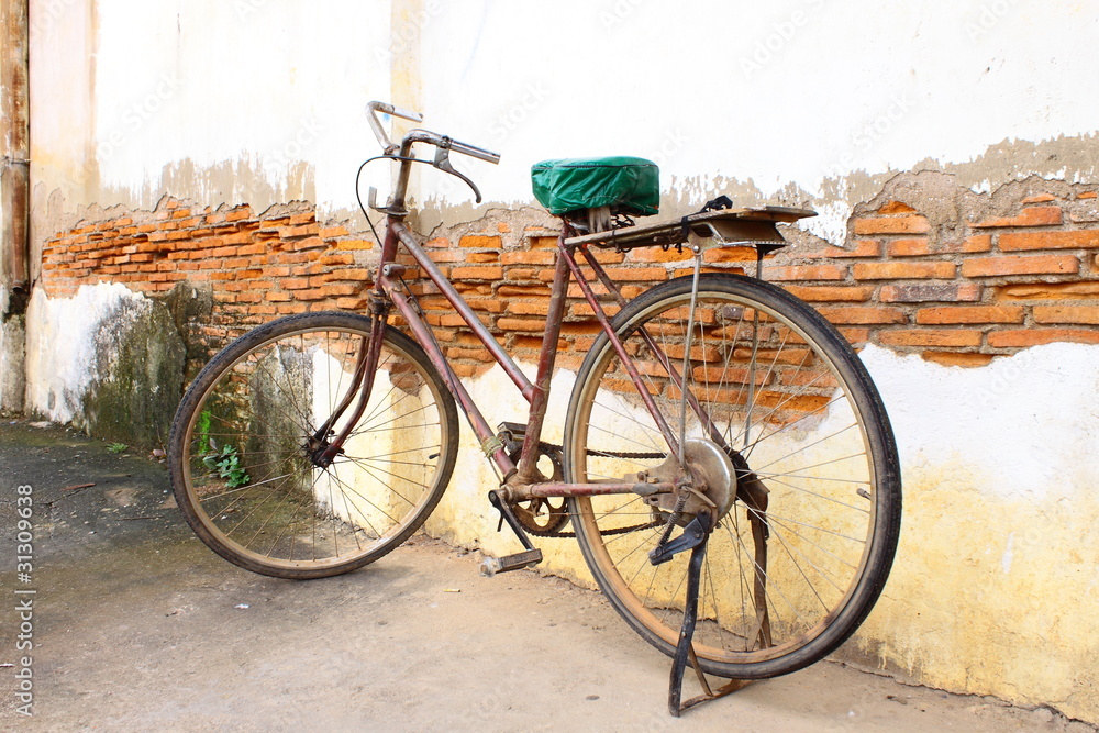 Obraz premium Old bicycle against old wall