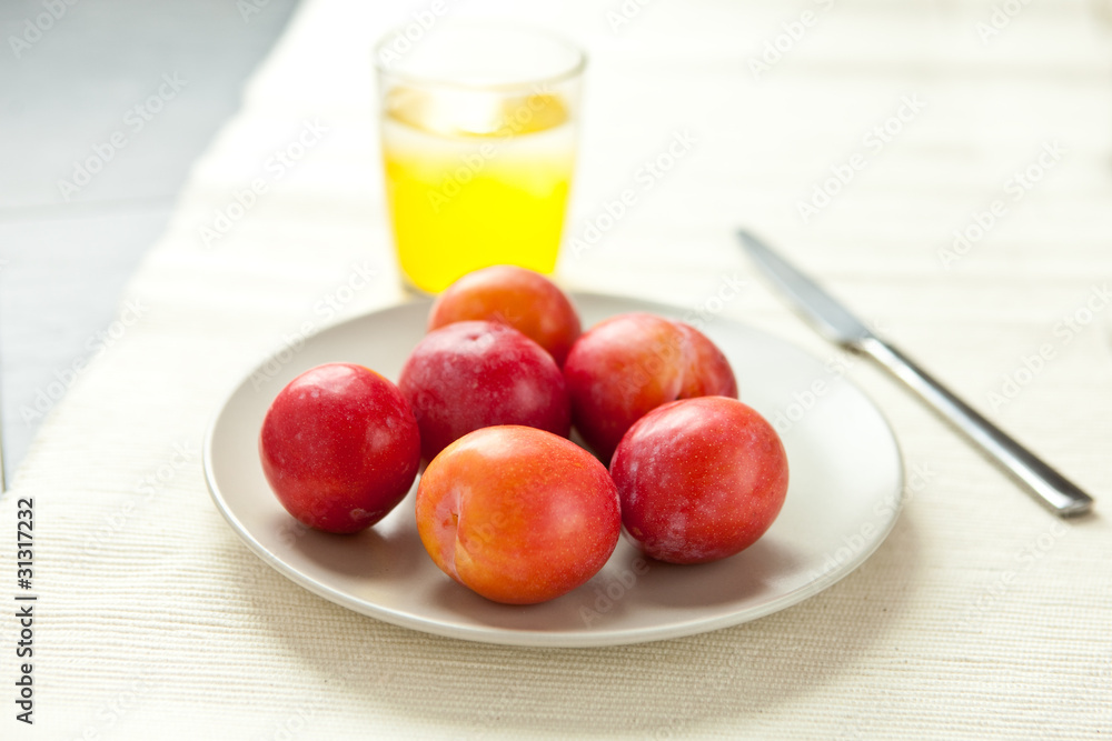 Fresh plums with a glass of juice Fresh plums with a glass of juice
