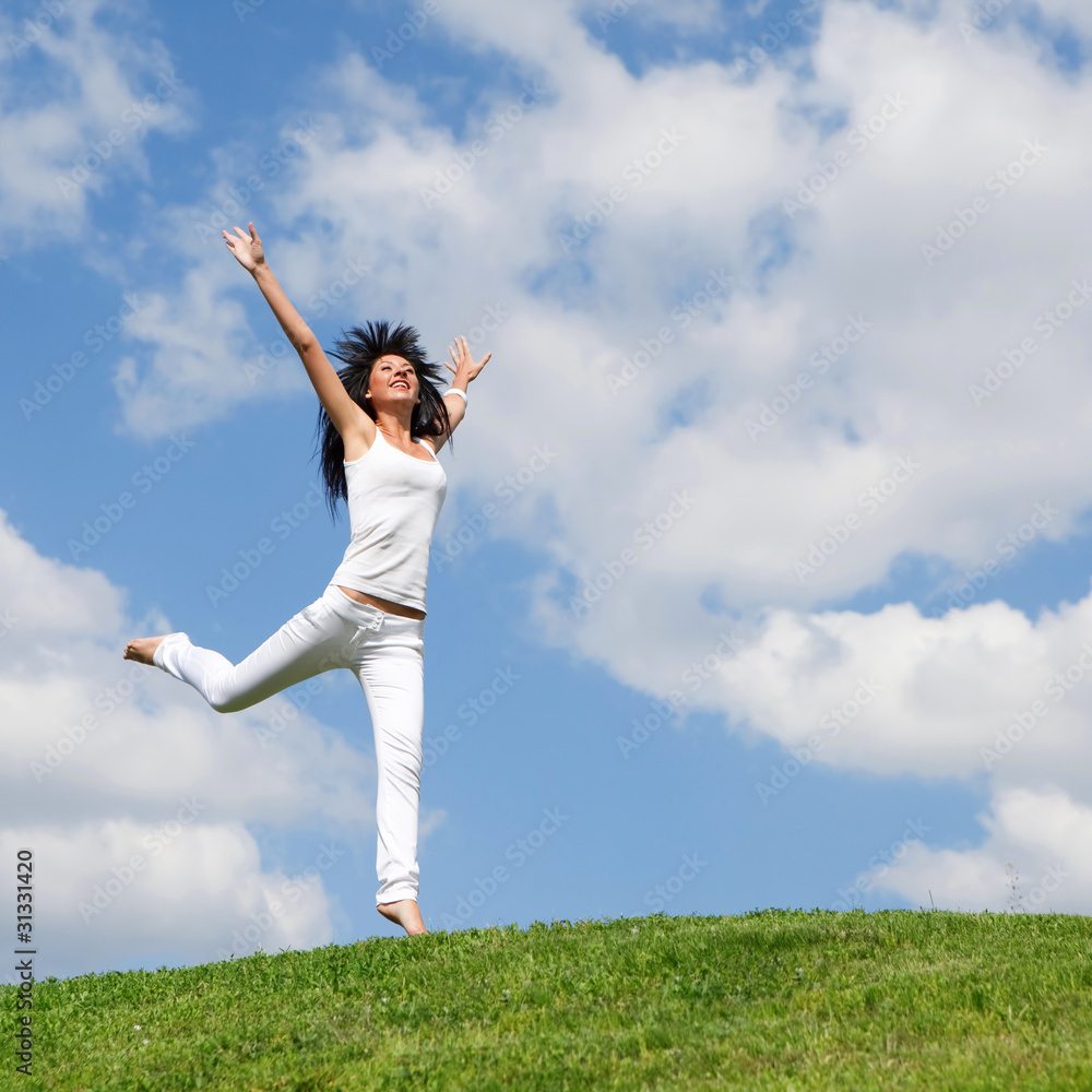 pretty young woman jumping on green grass