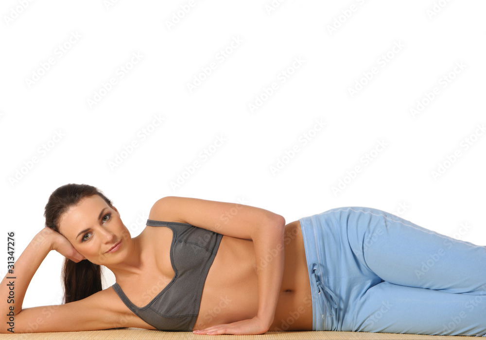 Fototapeta premium A young and sporty brunette is doing stretching exercises