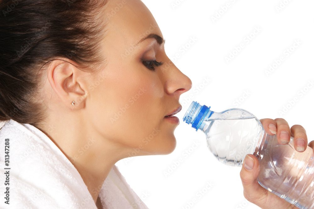 A young and sporty brunette woman is drinking fresh water A young and sporty brunette woman is drinking fresh water