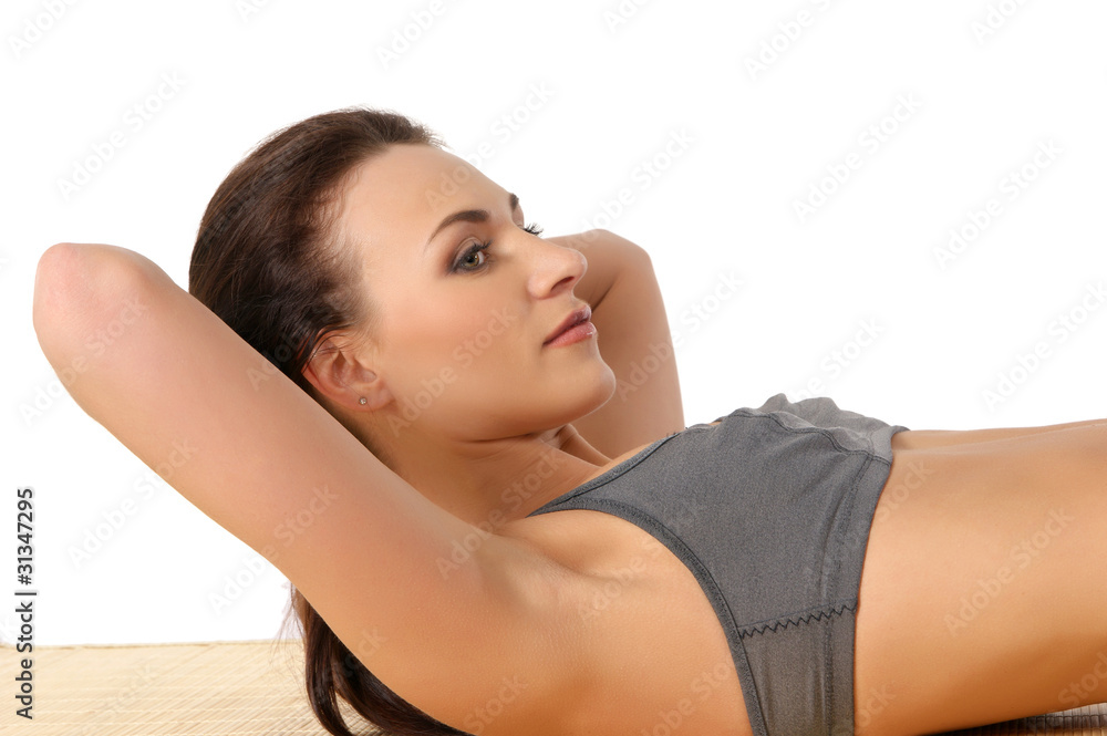 Obraz premium A young and sporty brunette is doing stretching exercises