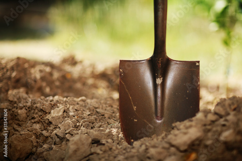 Shovel in soil. Closeup, shallow DOF. photo