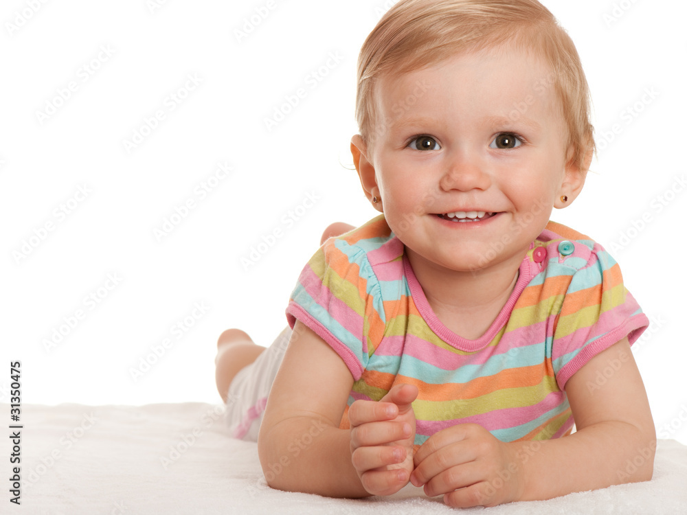 Cheerful little girl lying on the white Cheerful little girl lying on the white