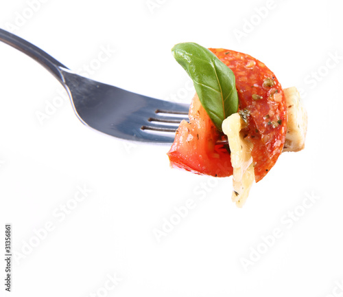 Taste of salad on a fork- farfalle, tomato, salami, mozzarella