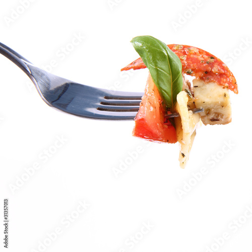 Salad on a fork - farfalle, tomato, salami, mozzarella, basil