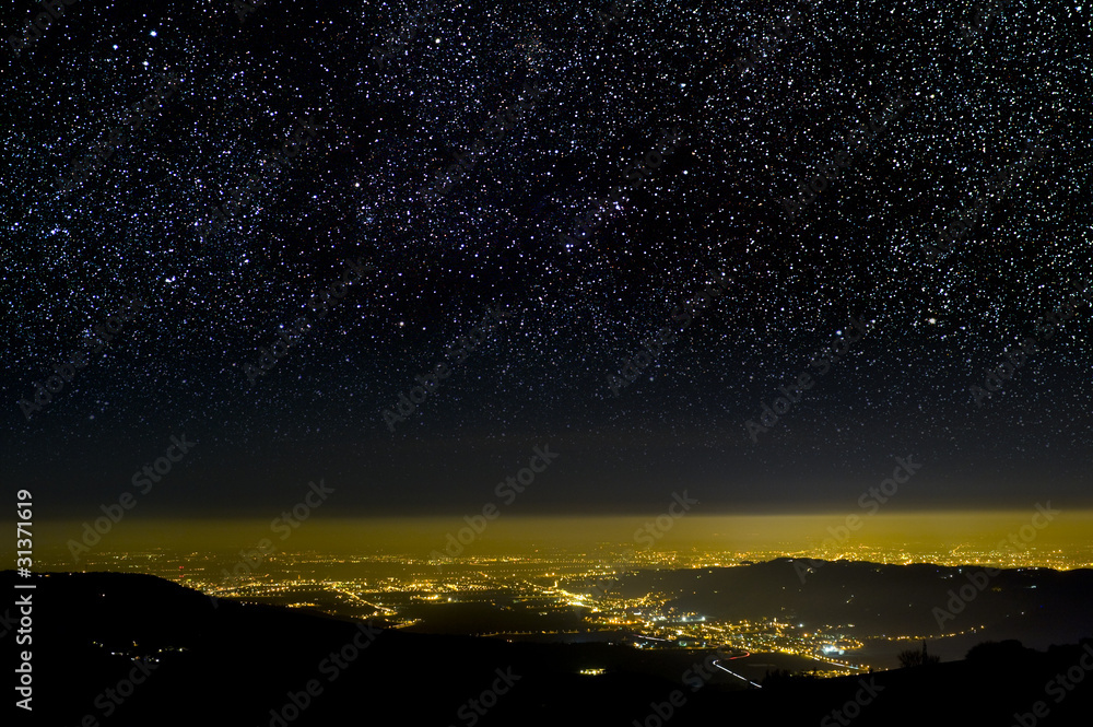 The Universe above city lights. The dark night sky.