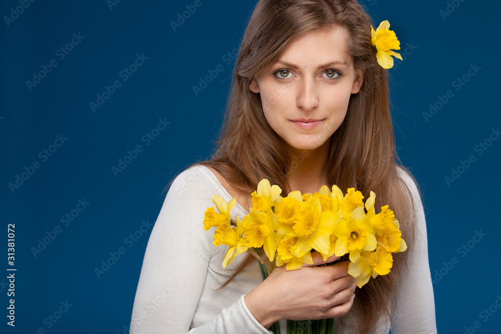 Young female with bunch of flowers on blue background Young female with bunch of flowers on blue background