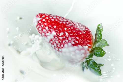 strawberry splashing into milk