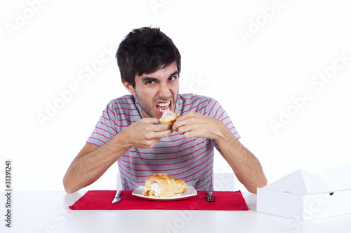 Young man eating a cake