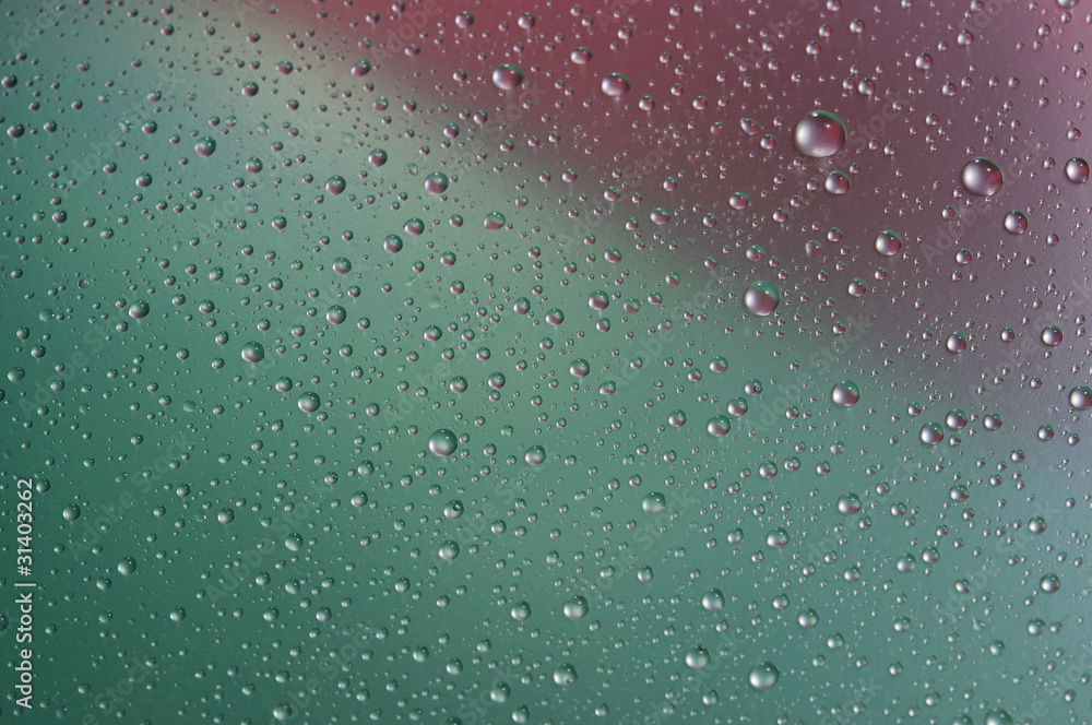 Fototapeta premium Капли воды крупным планом на разноцветном фоне