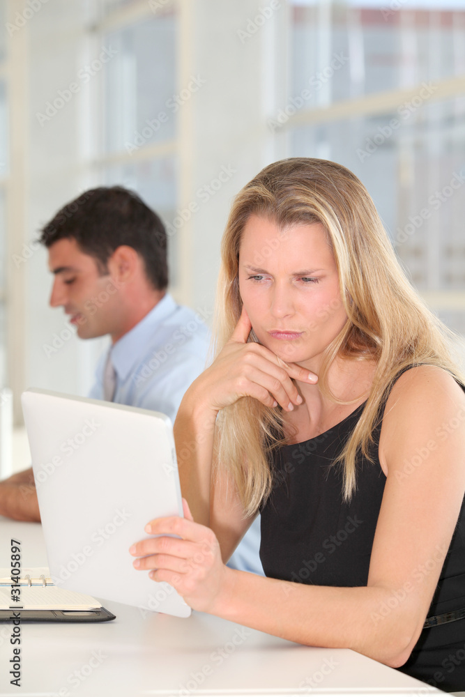 Businesswoman working in office with electronic tablet Businesswoman working in office with electronic tablet