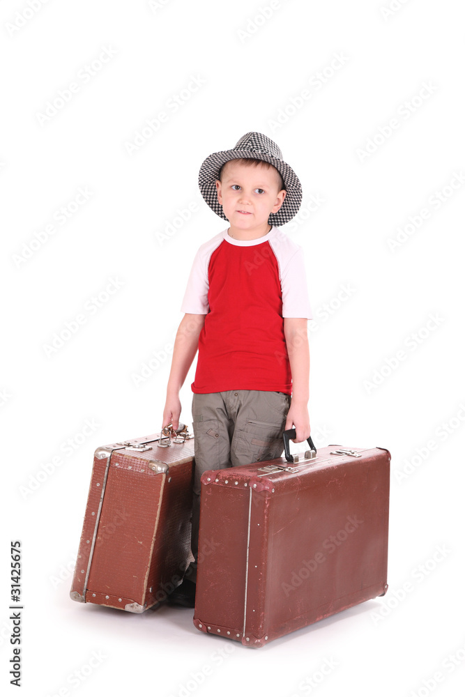 boy in a hat has control over old suitcases. boy in a hat has control over old suitcases.