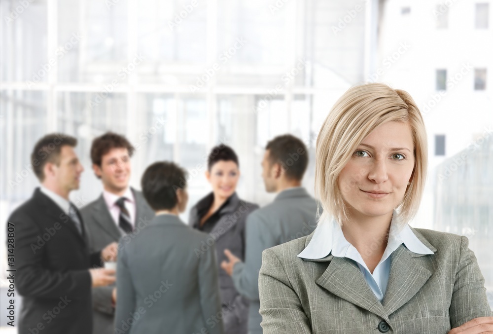 Smiling businesswoman in office lobby Smiling businesswoman in office lobby