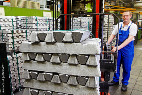 worker moving aluminum bars with a forklift photo