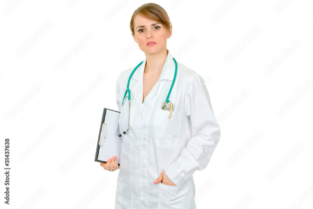 Thoughtful female medical doctor holding clipboard in hand Thoughtful female medical doctor holding clipboard in hand