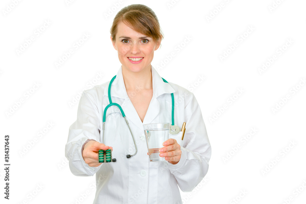 Female medical doctor giving packs of pills and glass of water Female medical doctor giving packs of pills and glass of water
