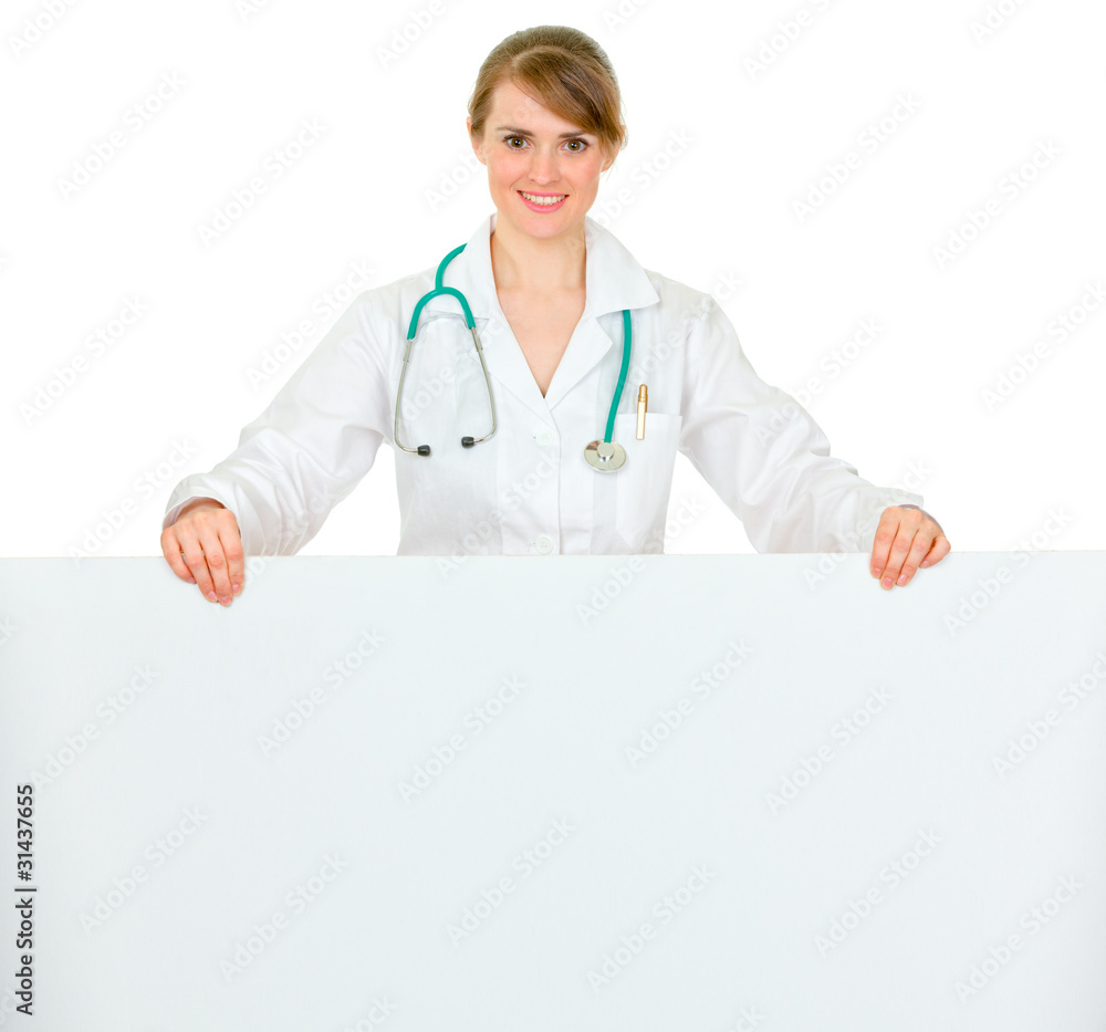 Smiling medical doctor woman holding blank billboard Smiling medical doctor woman holding blank billboard