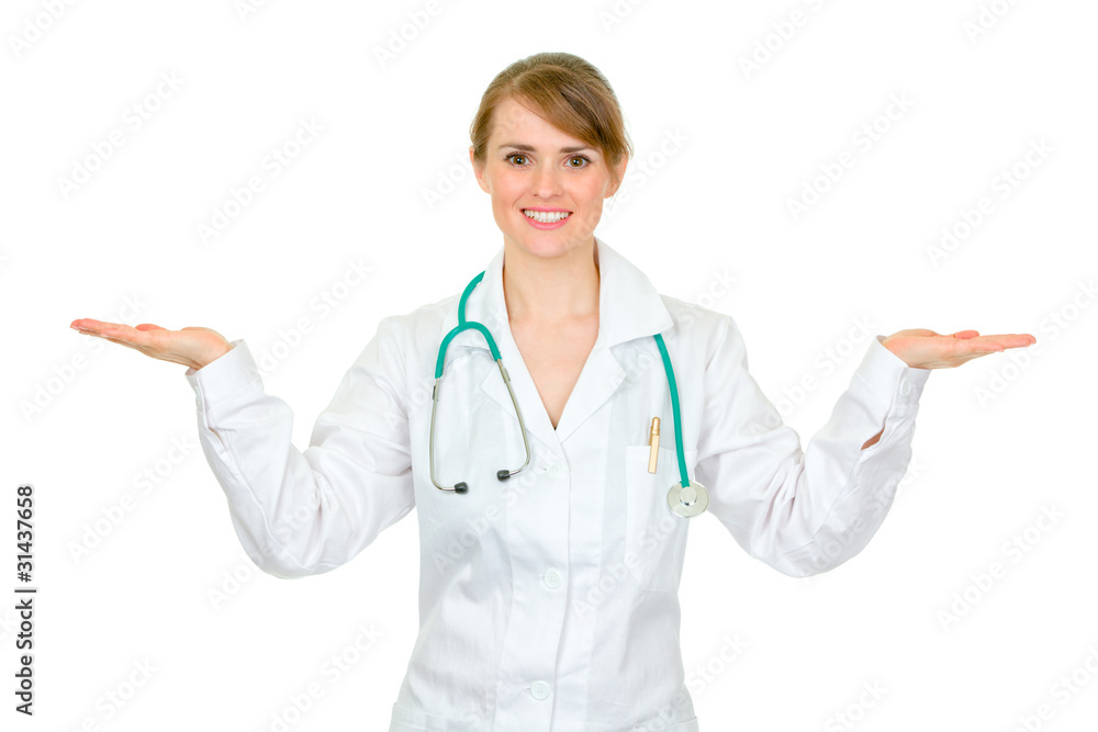 Smiling medical doctor woman presenting something on empty Smiling medical doctor woman presenting something on empty