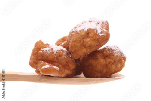 Oliebollen on a wooden spoon isolated on a white background
