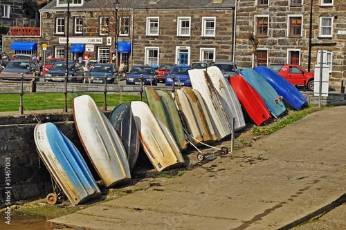 Many colourful rowing boats upended in the harbour of picturesque Porthmadog in Wales 