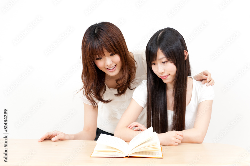 two beautiful asian women reading a book two beautiful asian women reading a book