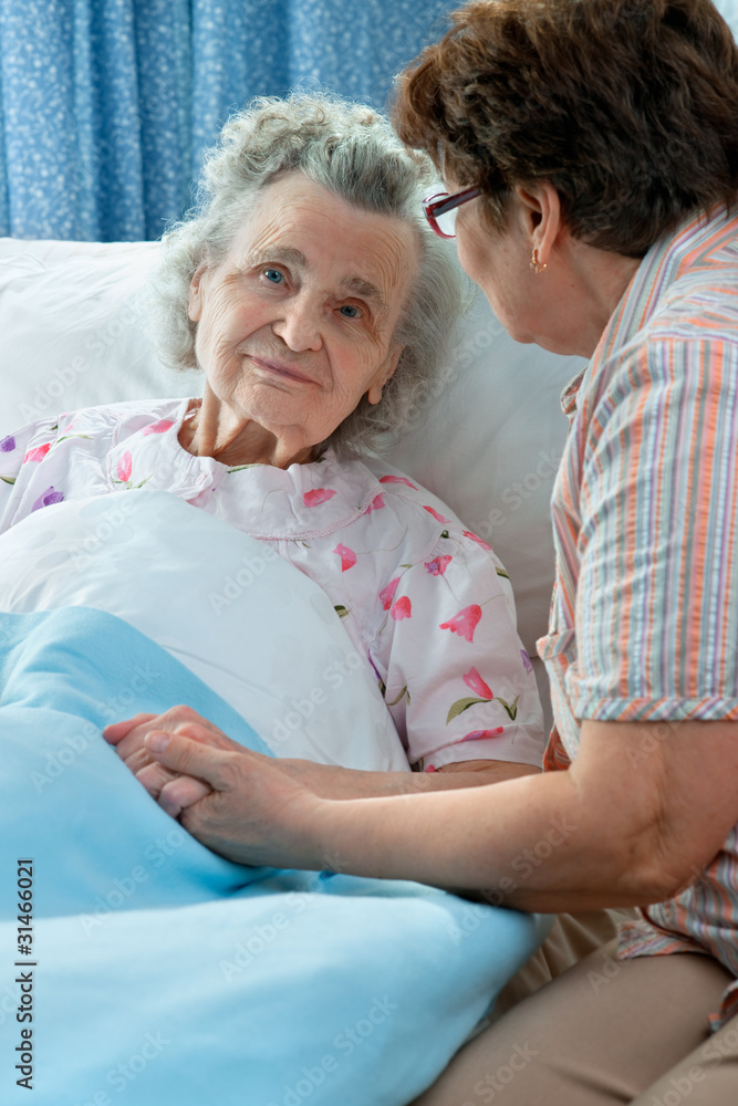 Senior female is being visited by the daughter in hospital Senior female is being visited by the daughter in hospital