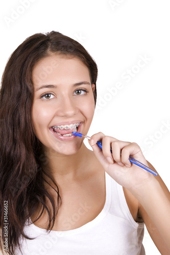 happy girl with braces brushing her teeth