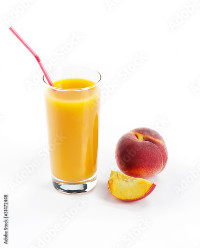 Glass with fresh peach juice near the slice peaches