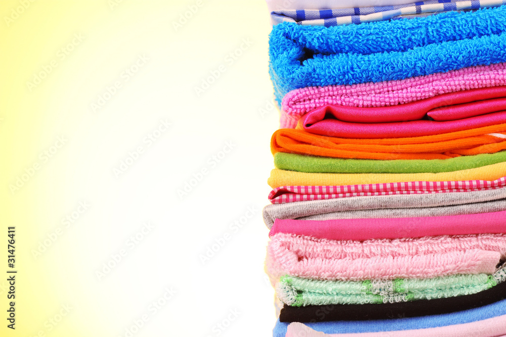 Pile of colorful clothes on yellow background Pile of colorful clothes on yellow background