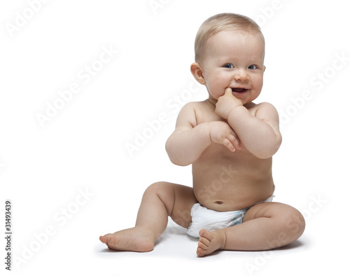 Foto Sweet little boy sitting with finger in the mouth