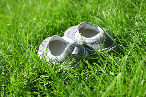 child's shoe for leisure in a green summer grass