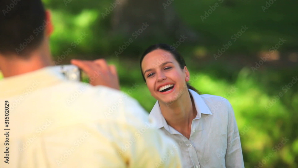 Dark-haired man taking a picture of his wife