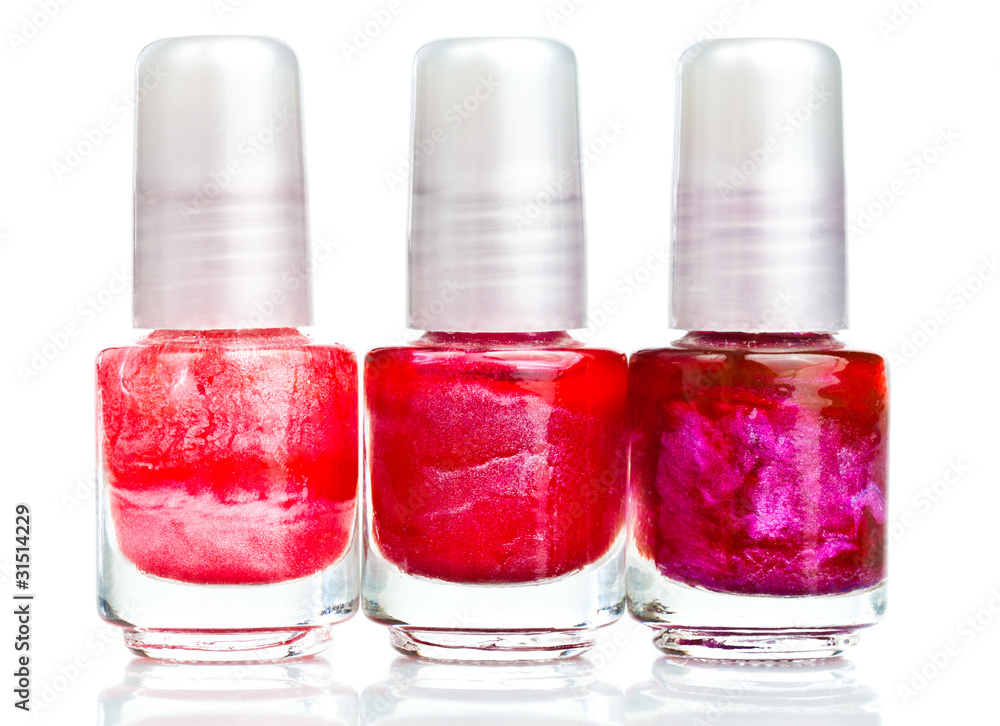 Nail polish bottles in shades of red on a white background Nail polish bottles in shades of red on a white background