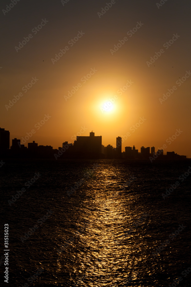 The sun setting over Havana with a silhouetted view of the city