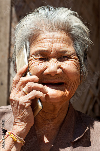 old asian woman with mobilphone photo