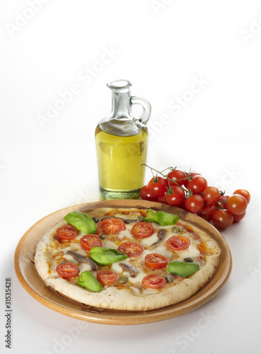 pizza con bottiglia di olio e pomodorini su fondo bianco