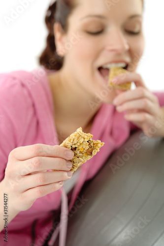 Fitness woman eat cereal bar sportive outfit