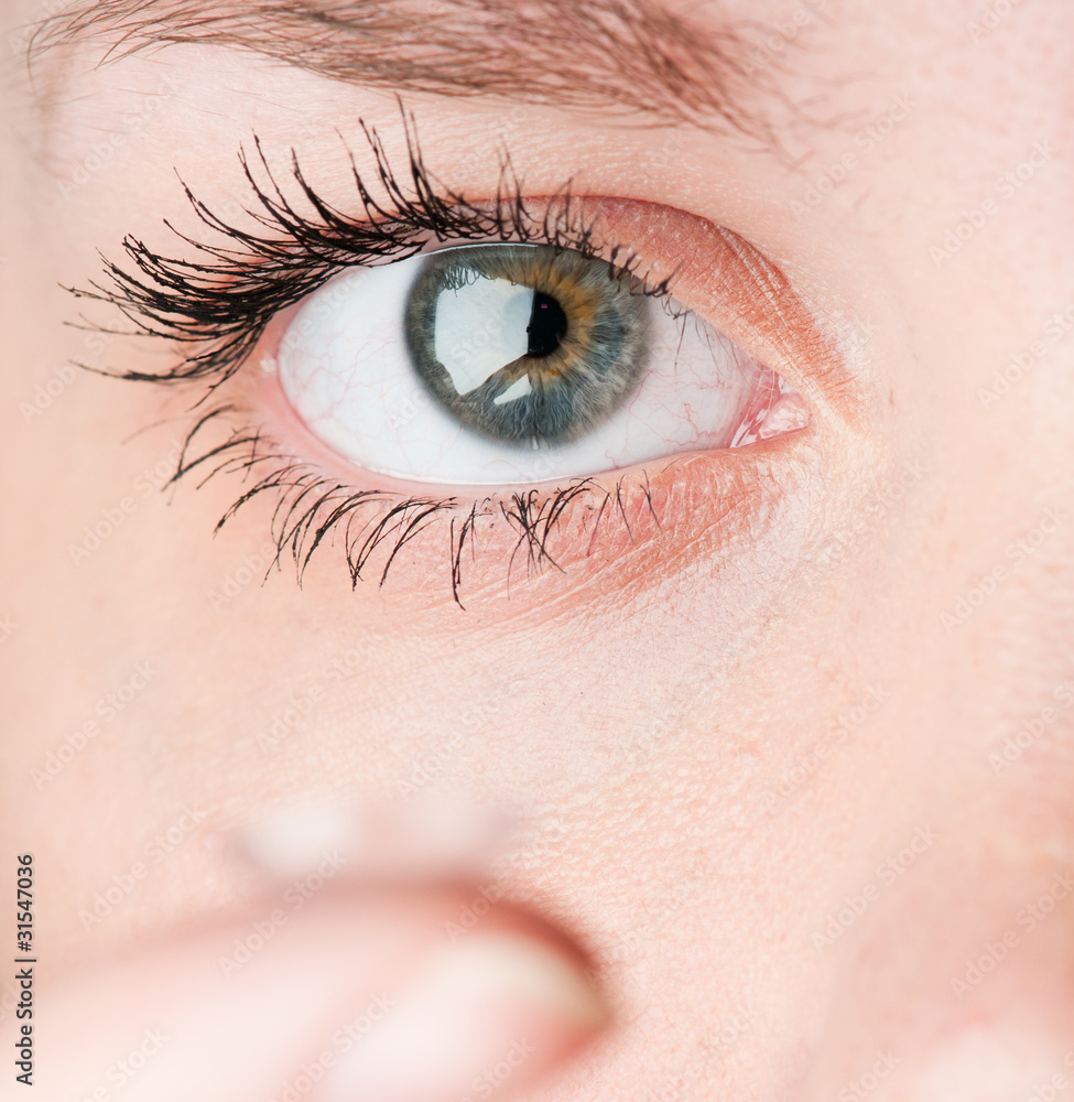 Close up of inserting a contact lens in female eye Close up of inserting a contact lens in female eye