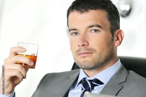 business man is drinking alchool at the office photo