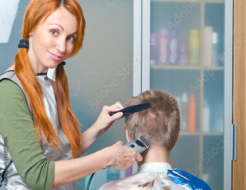 The young woman the hairdresser does a hairstyle to the client