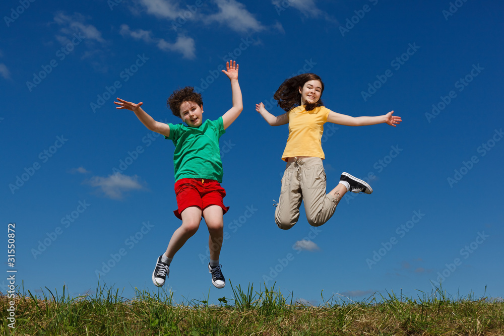 Girl and boy jumping, running against blue sky Girl and boy jumping, running against blue sky