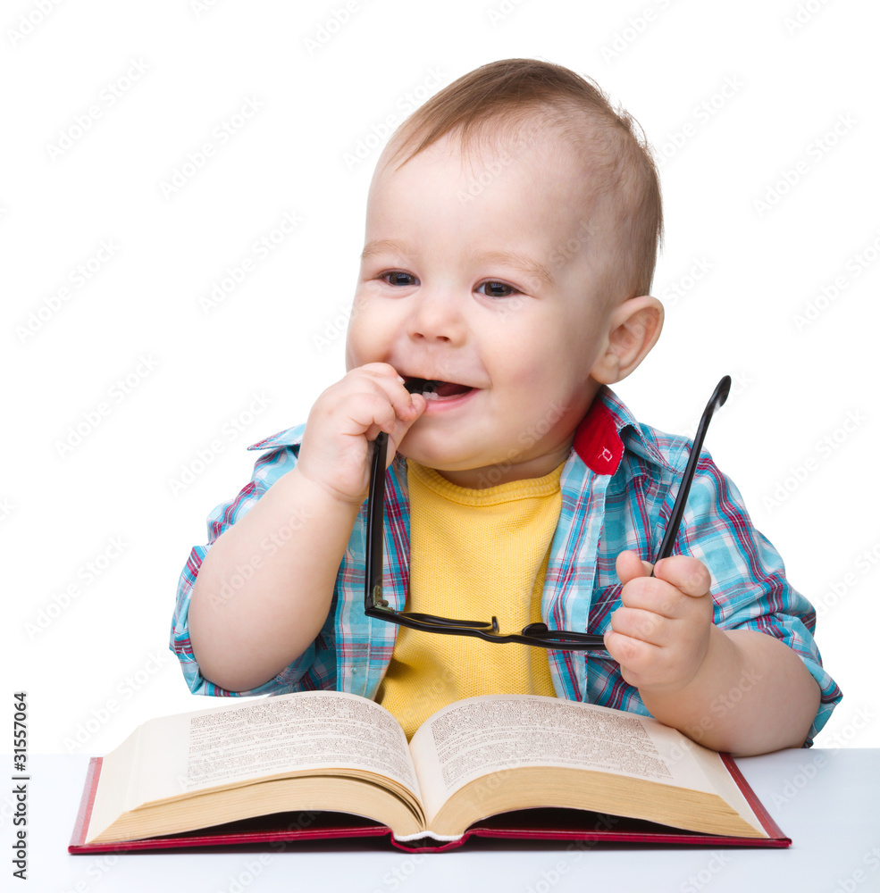 Little child play with book and glasses Little child play with book and glasses