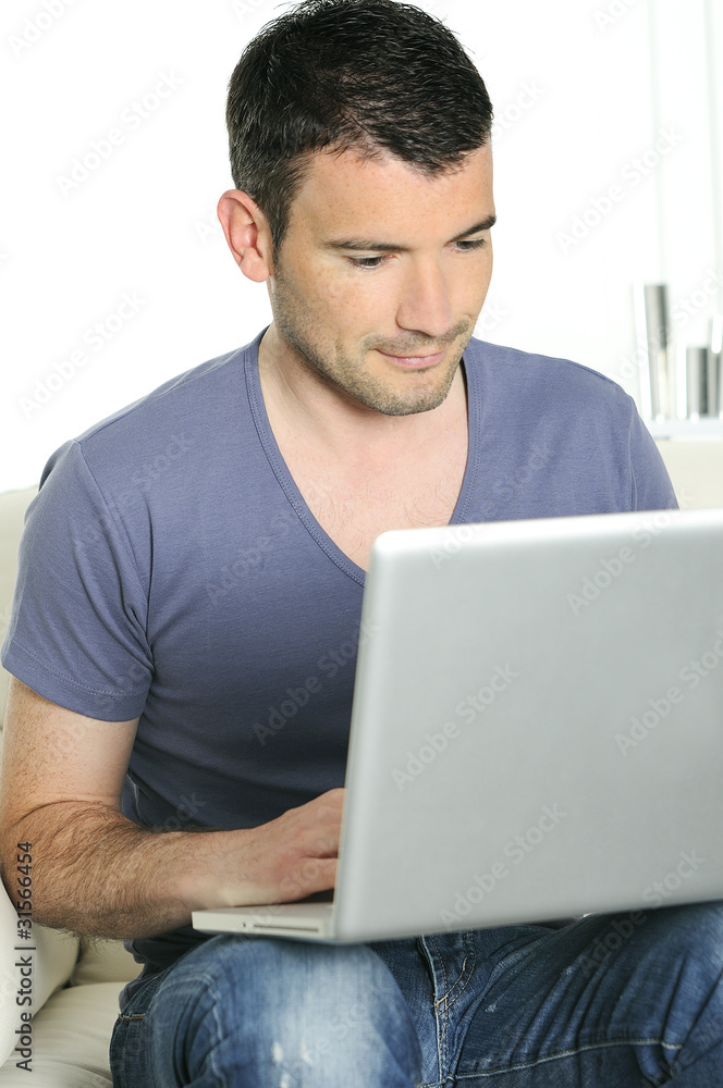 casual attractive man is surfing on web with his computer
