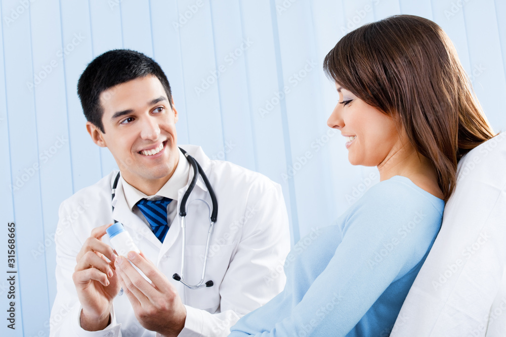 Happy doctor with medical drug and female patient at office Happy doctor with medical drug and female patient at office