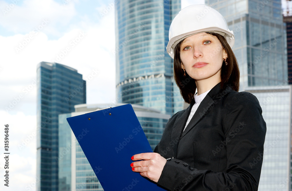 Female construction worker in hard hat on city background Female construction worker in hard hat on city background